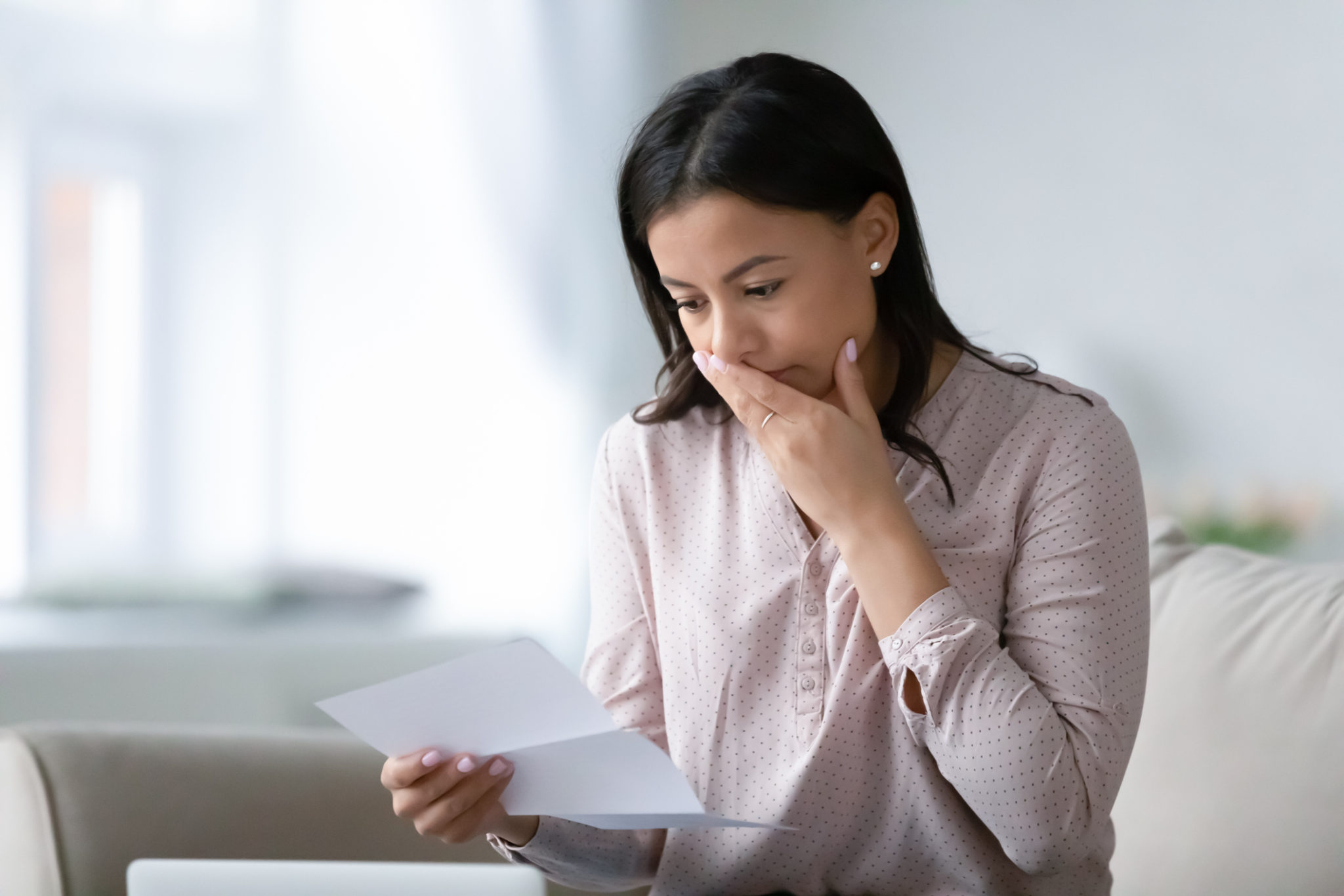 woman reading bad news in letter