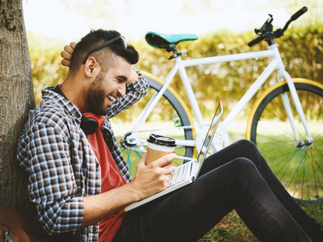 man with coffee cup and bike at local park