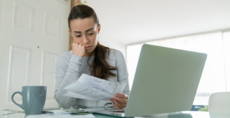 woman paying bills and looking worried