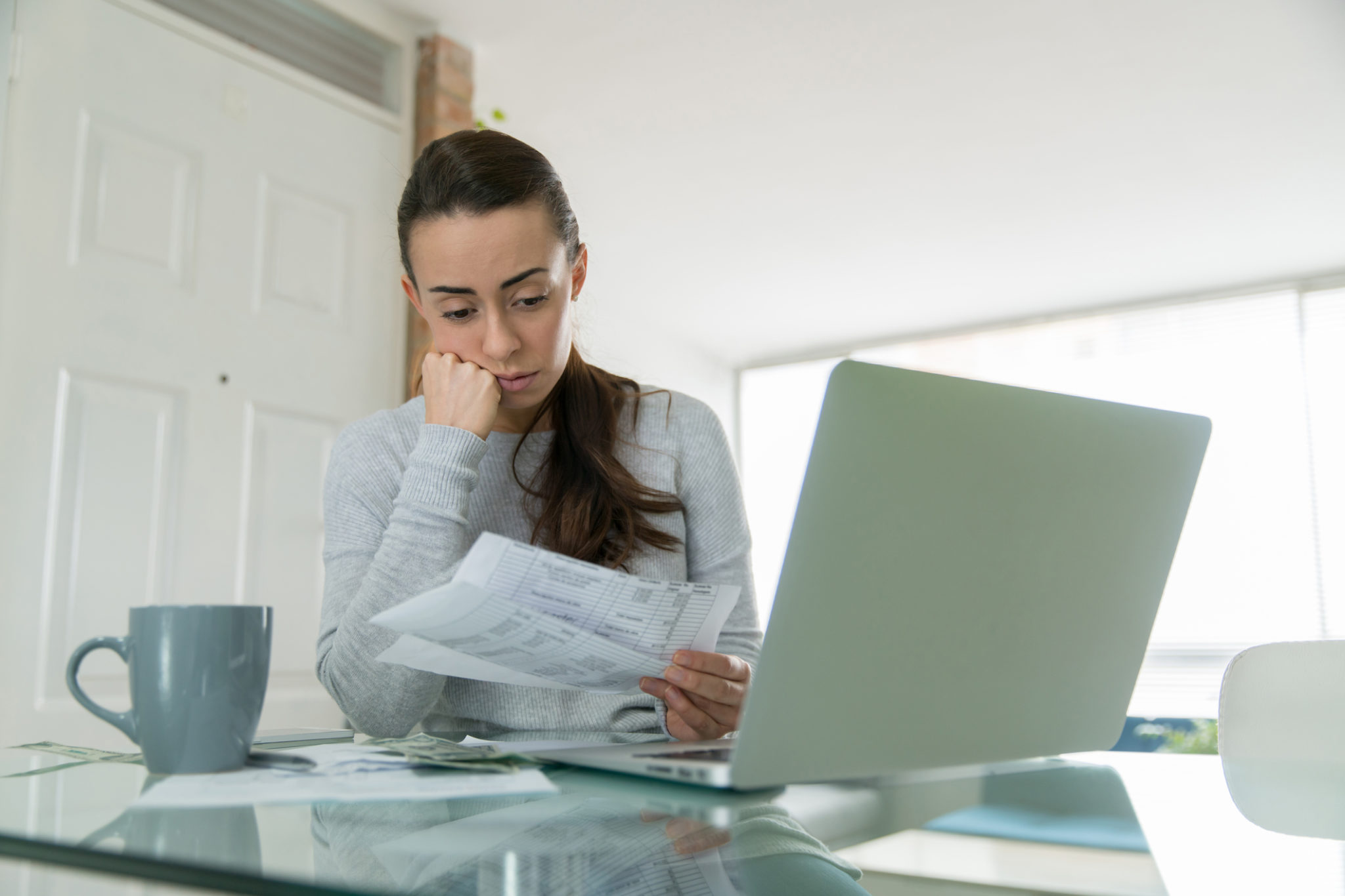 woman paying bills and looking worried