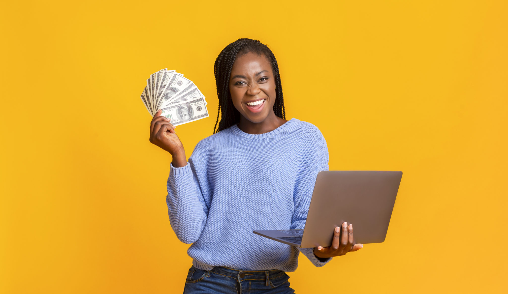 woman with money and laptop