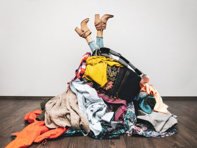 woman legs out of a pile of clothes on the floor