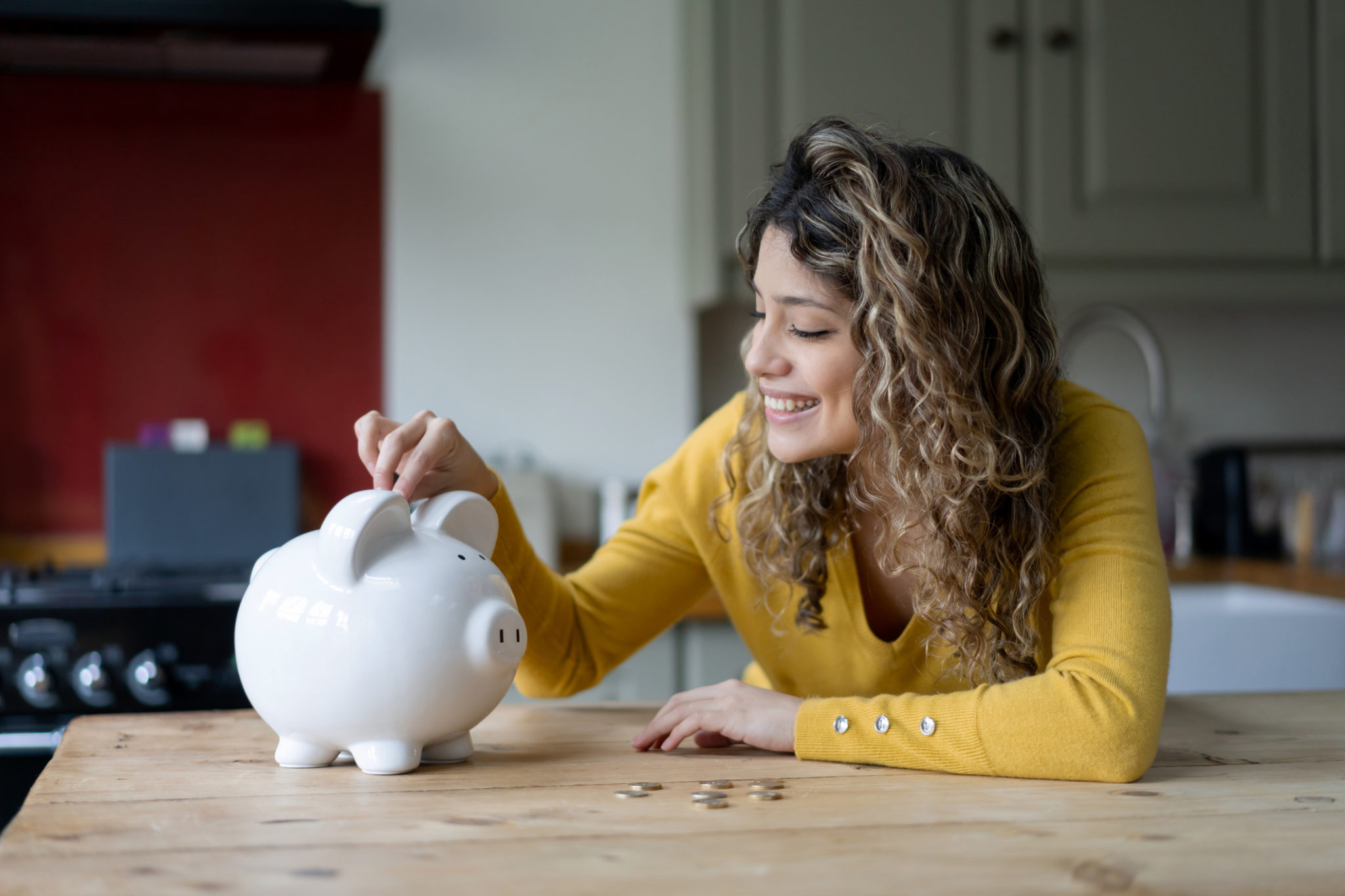 woman putting coins into her piggybank