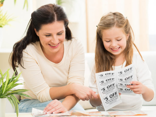 mother and daughter cutting coupons