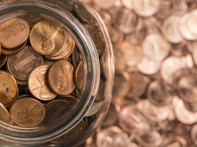 jar of pennies surrounded by pennies
