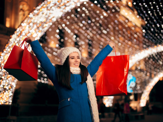 excited shopper holding shopping bags on christmas